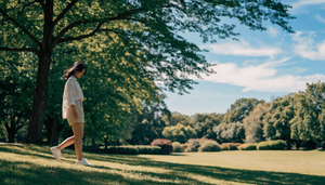 A woman comfortably walking and staying cool on a warm summer day in a shaded green park