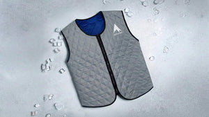 Grey quilted evaporative cooling vest surrounded by ice and water, conveying ultimate personal cooling comfort.