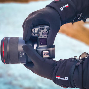 Person wearing Venture Heat gloves holding a Canon camera