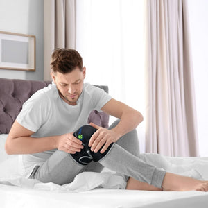 Man sitting on bed wearing a black knee brace