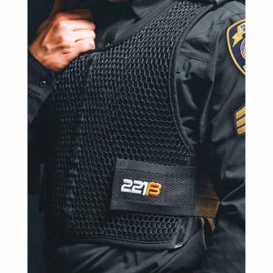 221B Tactical black mesh body armor vest worn over a uniform