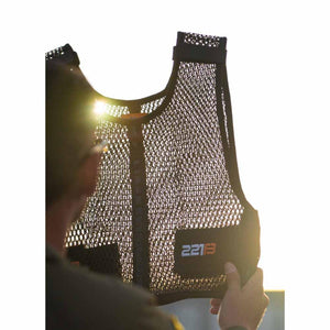 Person holding a 221B Tactical black mesh vest against sunlight