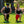 Man and woman wearing AlphaCool neck fans while performing lunges on grass