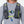 Person wearing a grey Nathan hydration vest with a chest mounted light and hydration tube