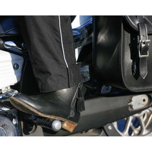 California Heat motorcycle pants and black leather boot resting on a foot peg