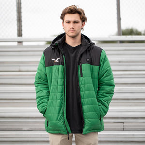 Man wearing a green and black ActionHeat hooded puffer jacket with an eagle logo