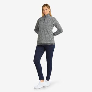 Woman wearing a Venture Heat grey heathered quarter zip pullover with dark blue jeans and white sneakers