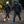 Two people wearing Venture Heat black puffer jackets walking on a rocky forest trail