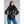Woman wearing a black 8K FlexWarm puffer jacket with a high collar and front zip pockets