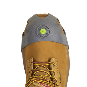 Winter Walking Spare Spike ice traction device on the toe of a tan work boot