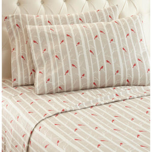 Beige bed sheets and pillowcases with a red cardinal and white birch tree pattern