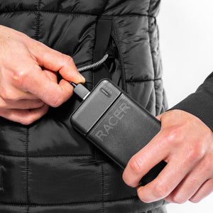 Person plugging a black Racer 10000mAh power bank into a heated jacket pocket