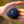 Outdoor Tech black circular wireless speaker held in palm
