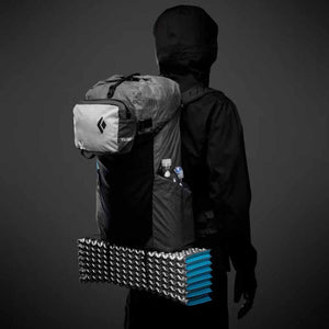 Person wearing a Black Diamond Beta Light backpack with a foam sleeping pad attached to the bottom