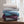 Stack of folded Serta heated blankets in assorted colors on a wooden surface