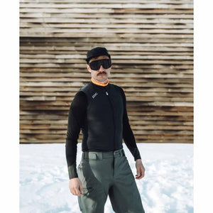 Person wearing POC black cycling vest and sunglasses standing in snow