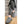 Person wearing grey cable knit ActionHeat slippers while sitting on carpeted stairs