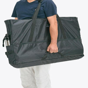 Person carrying a black Snow Peak storage bag with side pockets