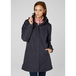 Woman wearing a navy Helly Hansen hooded rain jacket over a pink zip up fleece