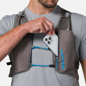 Person placing a smartphone into the zippered chest pocket of a grey Nathan hydration vest