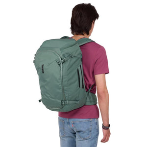 Person wearing a green Thule backpack