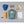 FjallRaven Kanken backpack with blue cap, Primus bottle, markers, notebook, apple, banana, and nuts on grey background