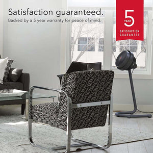 Vornado pedestal fan in a living room with a 5 year satisfaction guarantee graphic