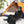Person in winter gear using a Zone Tech black fleece blanket while sitting in a chair outside a tent in the snow