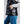 Person wearing a black quilted vest with a power button on the front