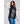 Woman wearing a black 8K FlexWarm puffer vest over a grey sweater and blue jeans