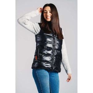 Woman wearing a black 8K FlexWarm puffer vest over a grey sweater and blue jeans
