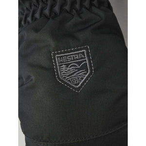 Hestra brand logo patch on black fabric glove