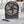 Black portable desk fan charging a smartphone on a marble countertop