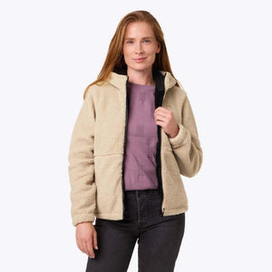Woman wearing a beige Mobile Warming sherpa fleece jacket with a hood