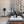 Vornado pedestal fan in a living room with a white coffee table and grey curtains