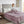 Person sitting on a bed covered by a purple Beautyrest heated blanket