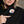 Person pressing the power button on a black ActionHeat Steelers heated jacket