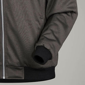 Close up of a grey bomber jacket with a silver zipper and black ribbed cuffs