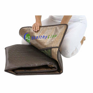 Person folding a HealthyLine mat with a textured gold surface