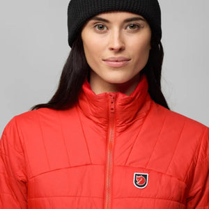 Woman wearing a black beanie and a red Fjallraven quilted jacket