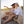 Two women wearing Mission visors sitting on a sandy beach