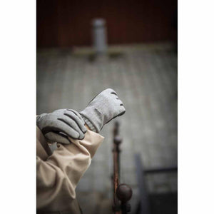 Person wearing grey Hestra gloves with dark brown palm details