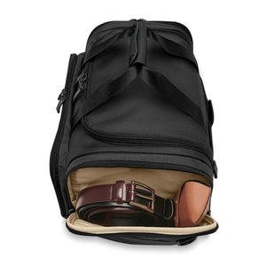 Briggs and Riley black duffel bag with open side pocket containing a brown leather belt and a small case