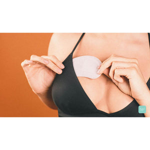 Person applying a silicone chest pad to their skin