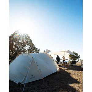 Snow Peak tent set up on a rocky campsite with a sunlit sky