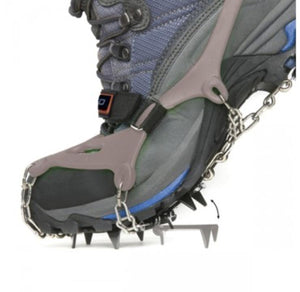 Hiking boot fitted with metal ice traction cleats and chains