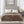 Beautyrest brown heated blanket with two controllers on a bed with a grey tufted headboard