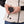 Person holding a Mobile Warming battery pack near the pocket of a cream fleece vest