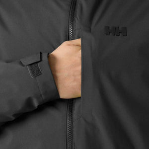 Hand in the pocket of a black Helly Hansen jacket with velcro cuff detail