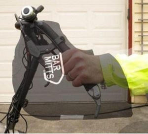 Hand inside a black Bar Mitts handlebar cover on a bicycle